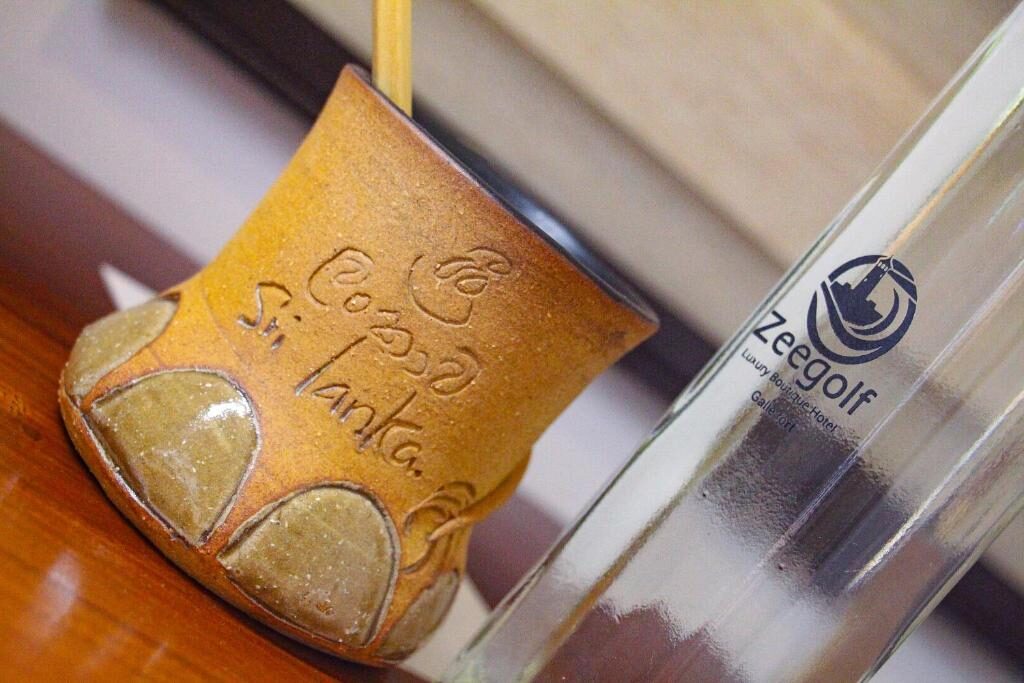 Hand-thrown Ceylon clay cup beside a Zeegolf water bottle