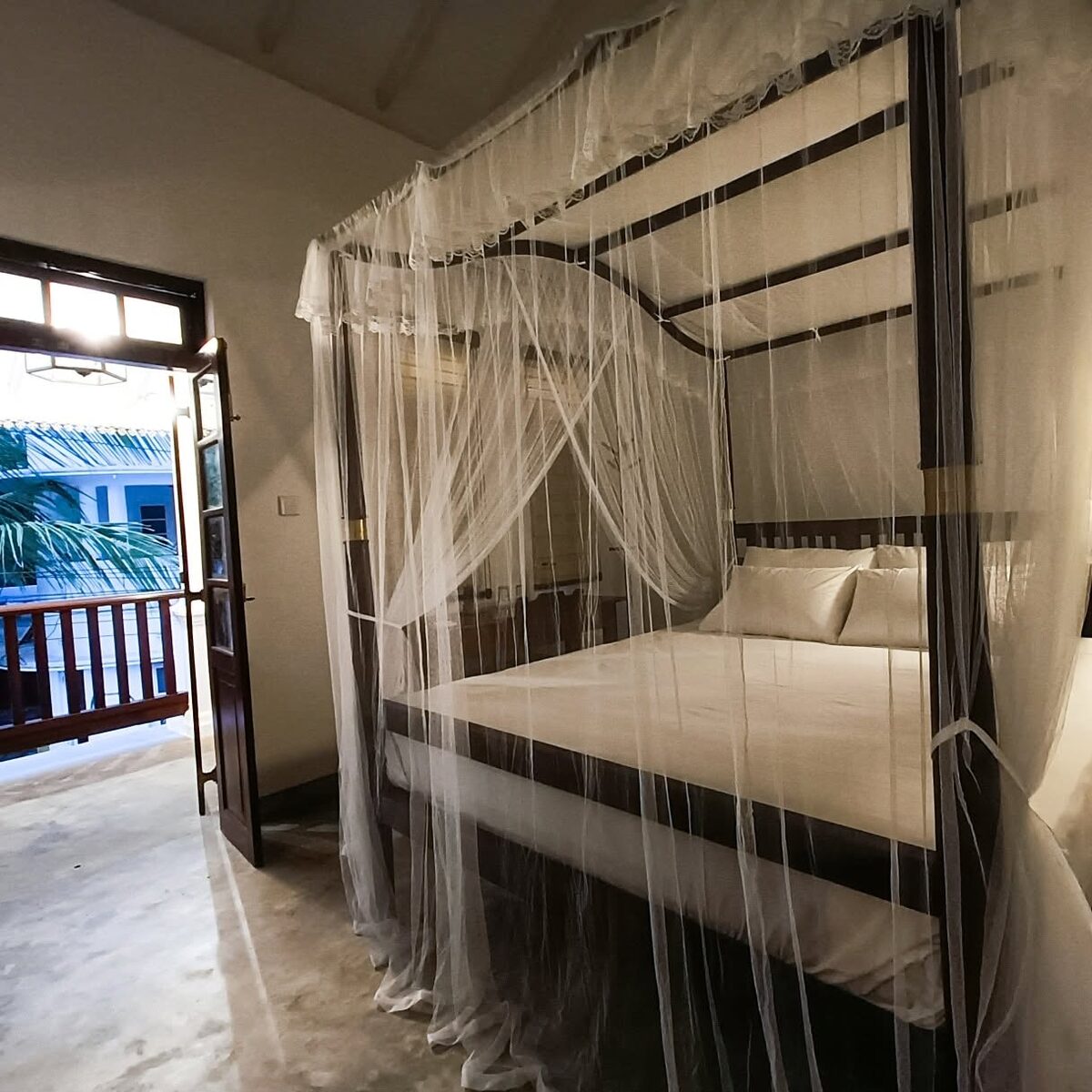 Four-poster canopy bed with white netting