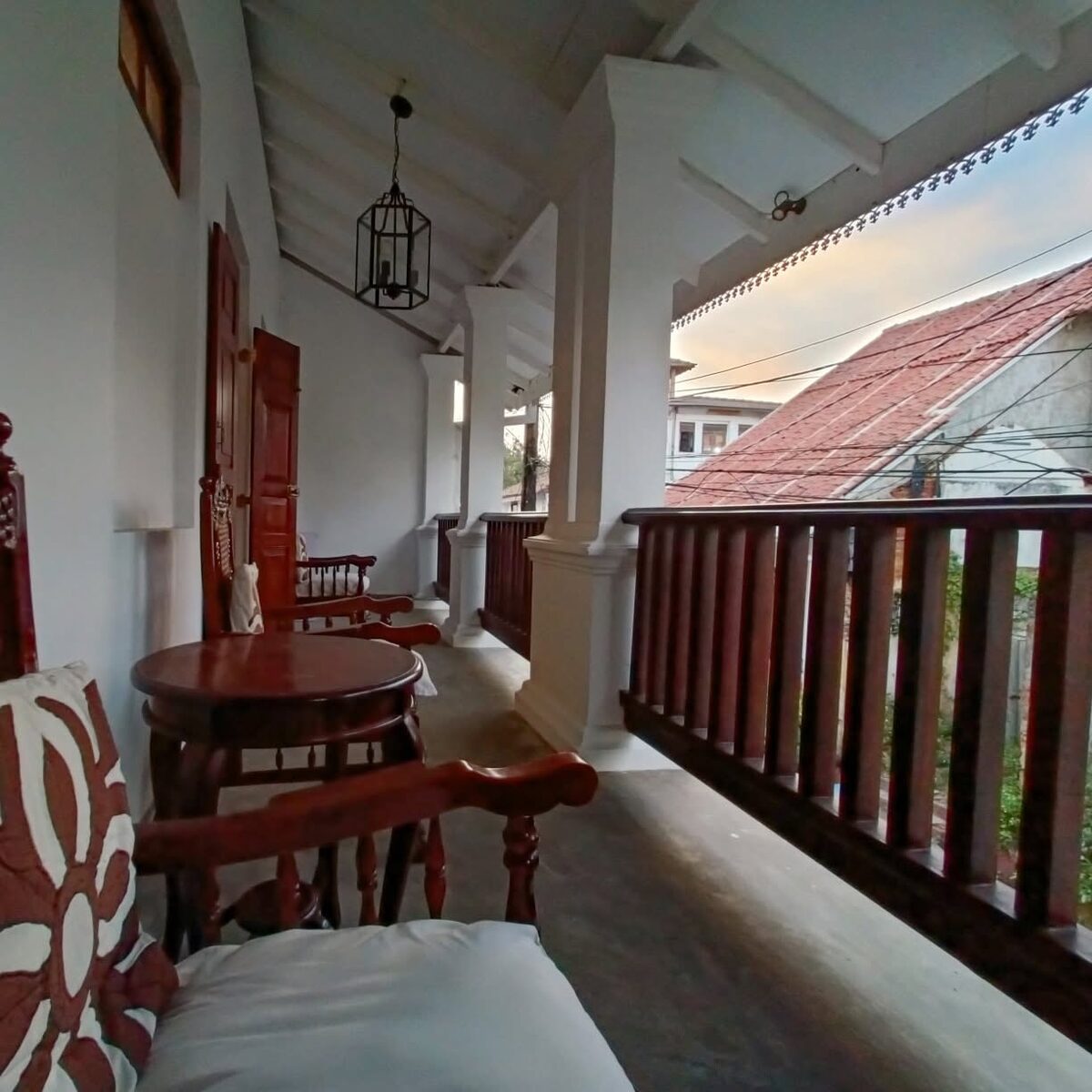 Upper verandah at sunset with lantern and teak chairs